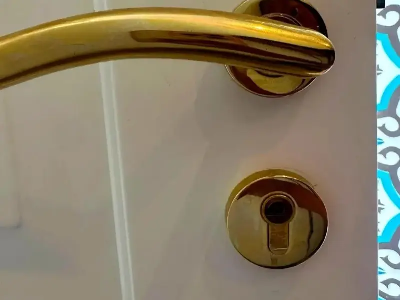 Manilla dorada y bombín nuevos en una puerta lacada